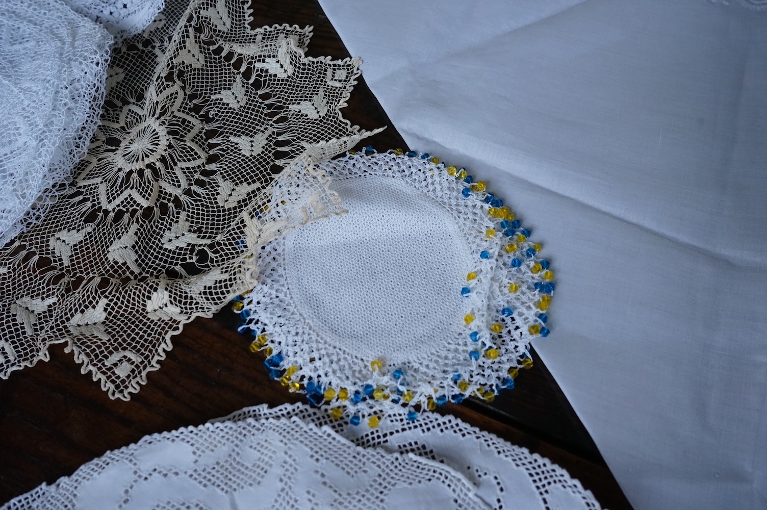 A 19th century large linen cut work collar, together with various sets of circular cut work mats, a tasselled pelmet and a collection of bobbin lace and tatting worked mats etc., Condition - mostly good